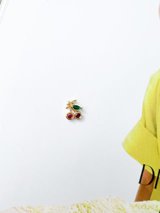 Cherry-shaped charm on a white background