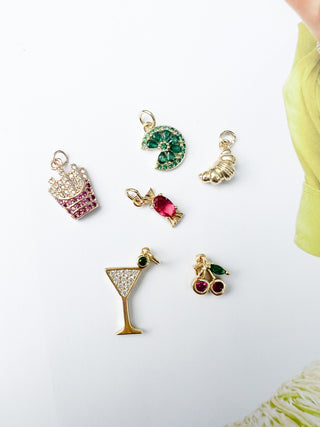 Collection of colorful jewelry charms on a white surface